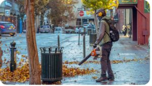 a person using a leaf blower on a city street