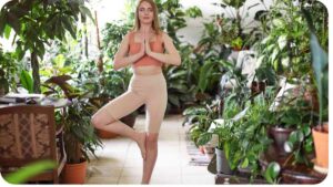 a person is doing yoga in a room full of plants
