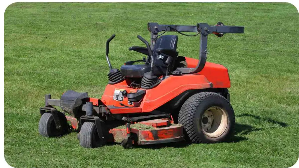 an orange lawn mower sitting on top of a green field