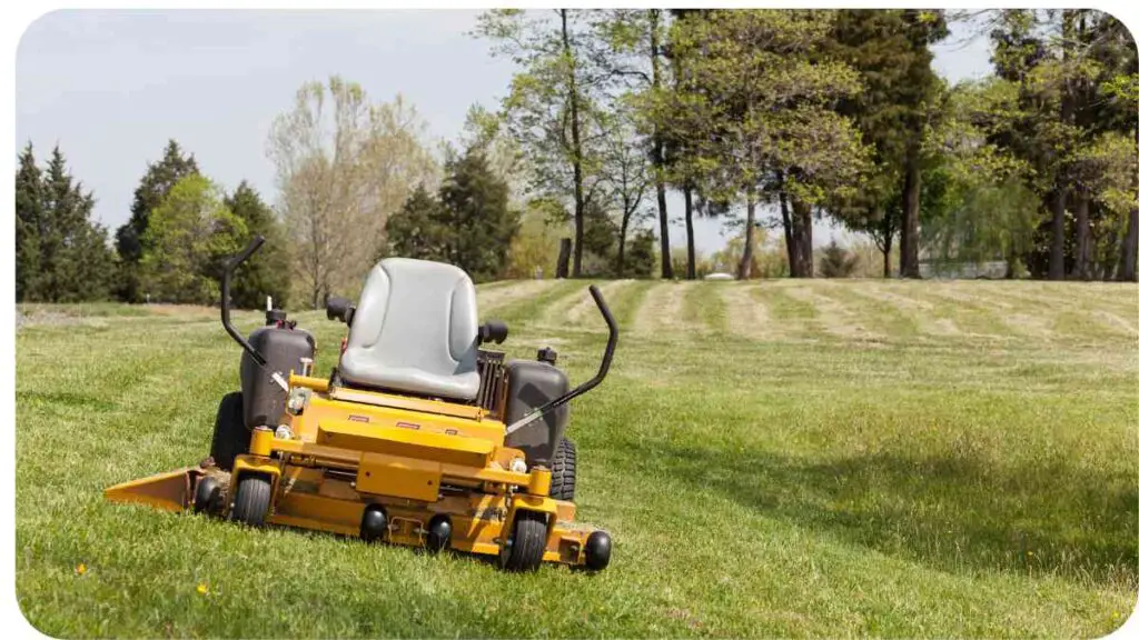 a yellow lawn mower sitting on top of a grassy field