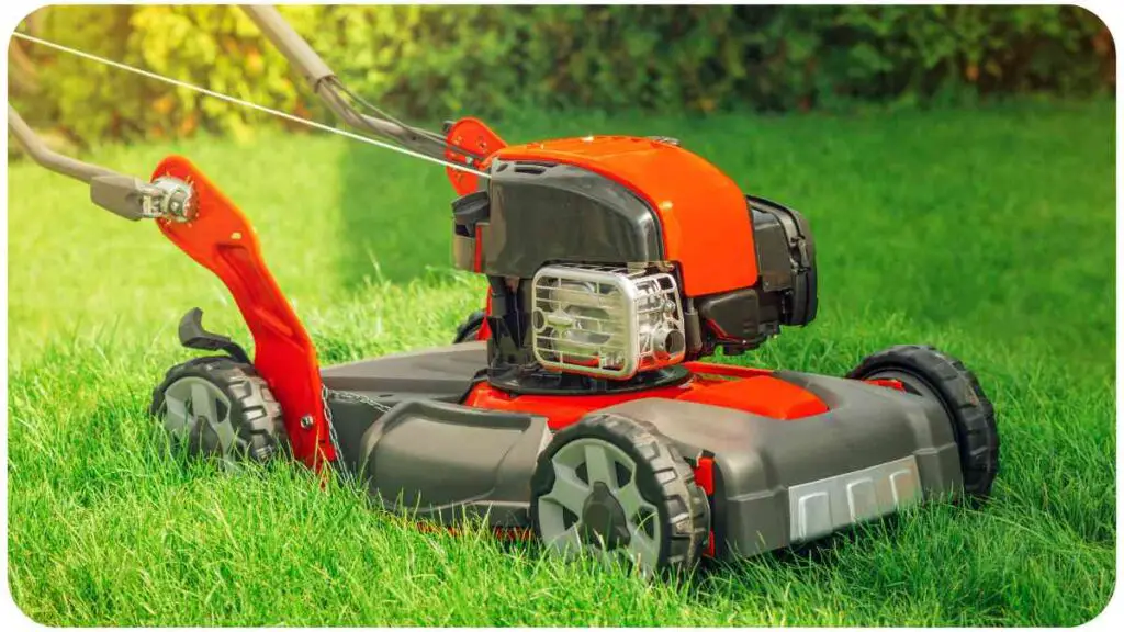 an orange lawn mower is sitting in the grass