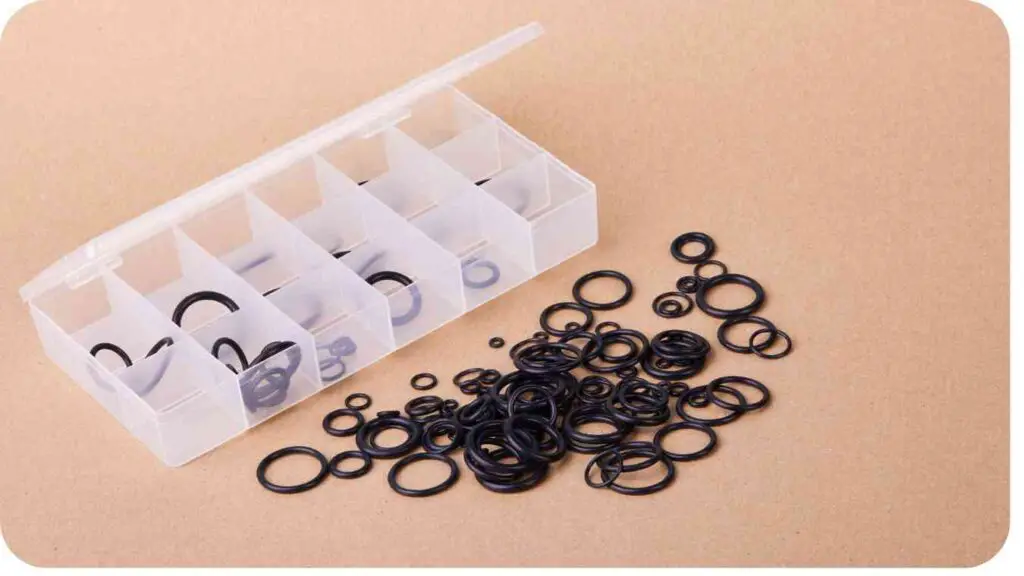 an assortment of black rubber o rings in a plastic container