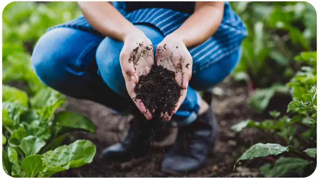 a person is holding soil in their hands in a garden