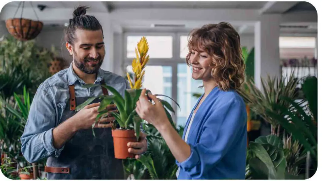 A person holding potted plants in a florist shop