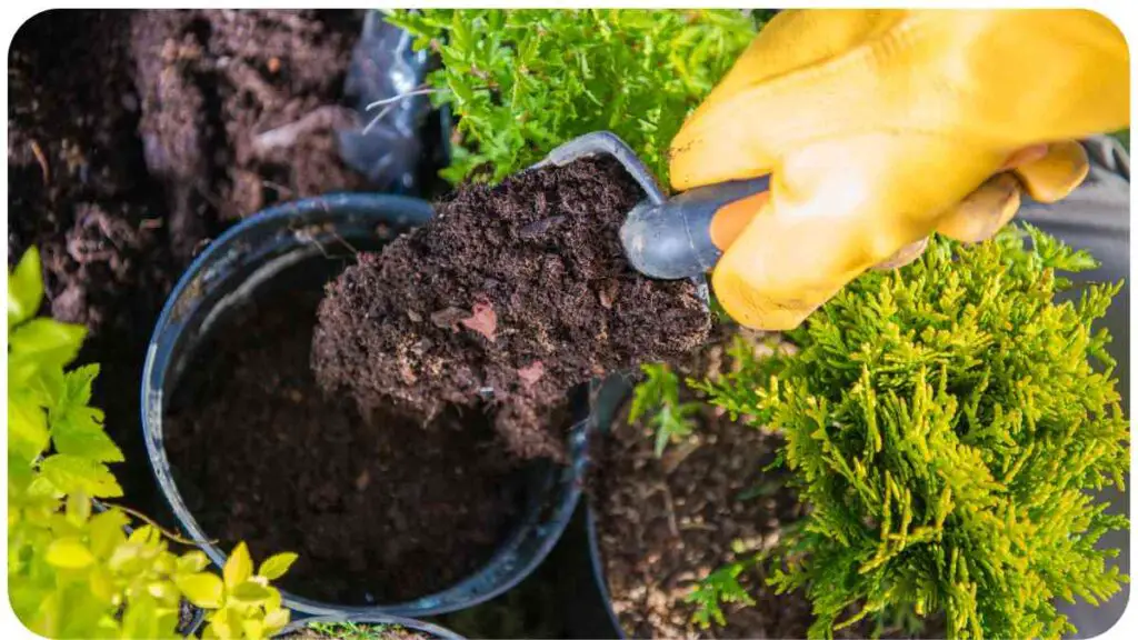 a person in yellow gloves is using a shovel to dig dirt out of a potted plant