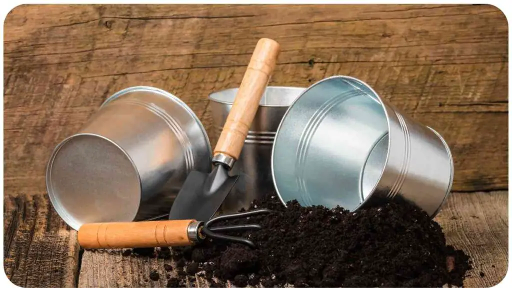 gardening tools and soil on a wooden table